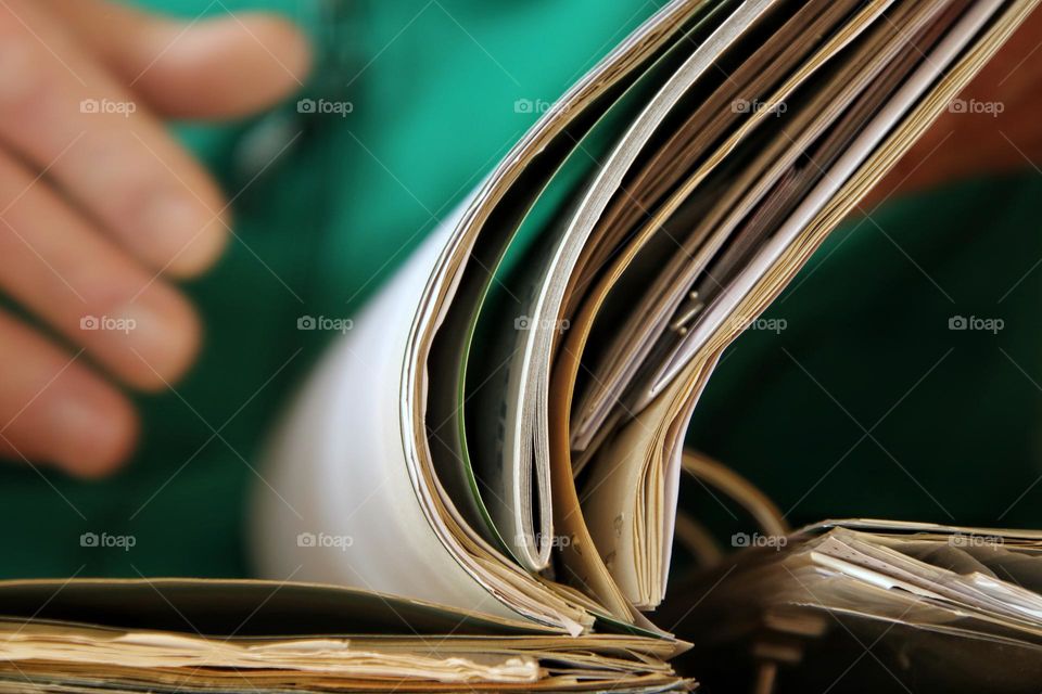 Close-up of a man's hand leafing through a folder