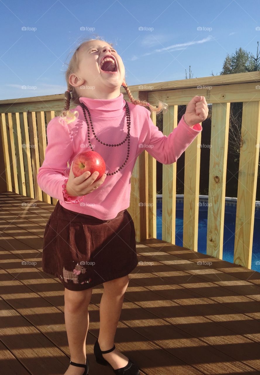 Cute girl holding apple in hand