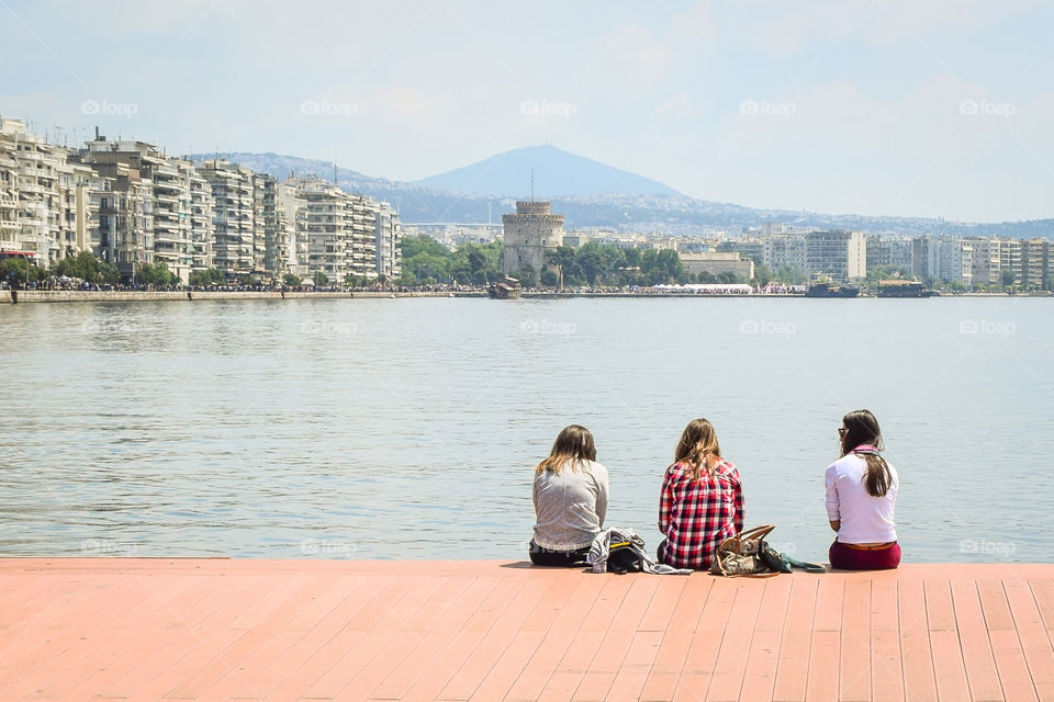 Friends Sitting On The Dock Enjoying The View
