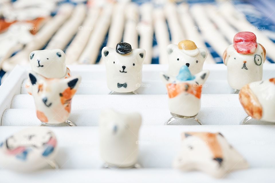 Animal rings are on sale. Ceramic rings with soft focus on the cute polar bear ring at the weekend market. Lady accessories and fashion rings.