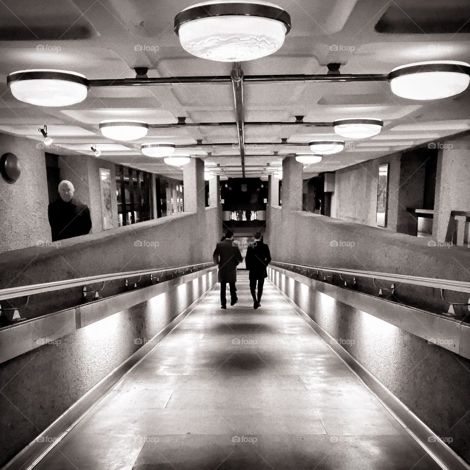 Men walking down a lit path to the Barbican Centre in London