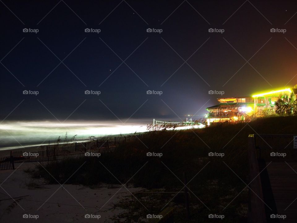 Night at the beach. A big party at the beach after a long day! Drinks served with live music. Stars are up and bright as well as lights in the ocean on a warm night! 