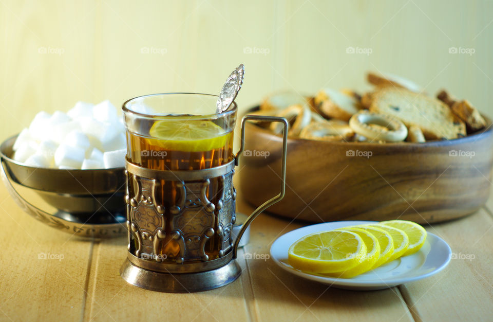 Tea in a glass in an old cup holder with drying and lemon