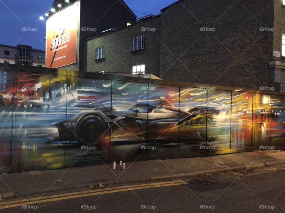 Graffiti mural of fast car with blurred effect on dark background in shoreditch, east London, taken at nighttime.