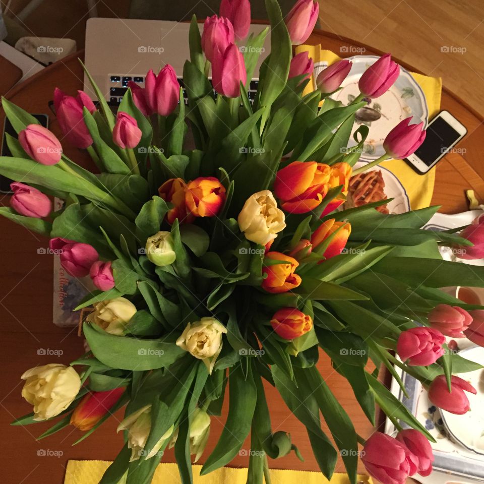 Bouquet of tulips on a wooden table.