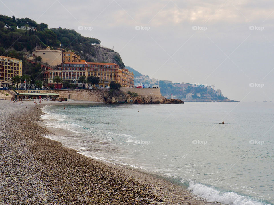 View of sea and coastline from the pebbled beach in Nice, France.