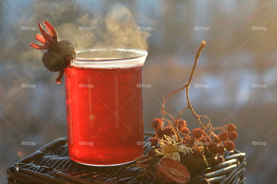 Glass jar of hot steaming tea with pomegranate