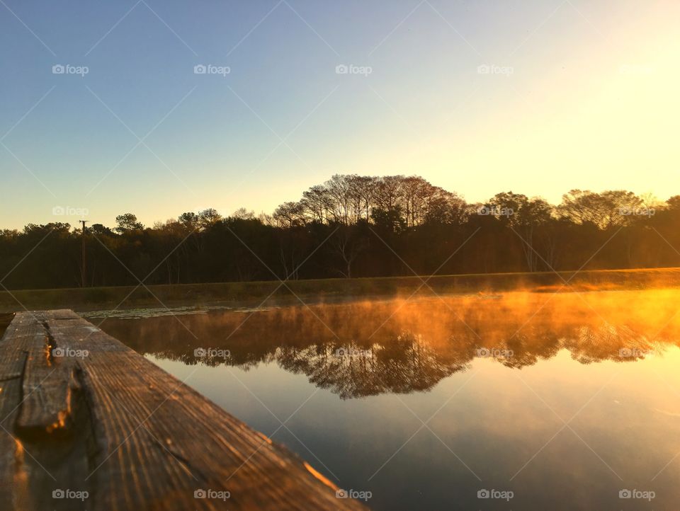 Fog lifting from river during sunrise
