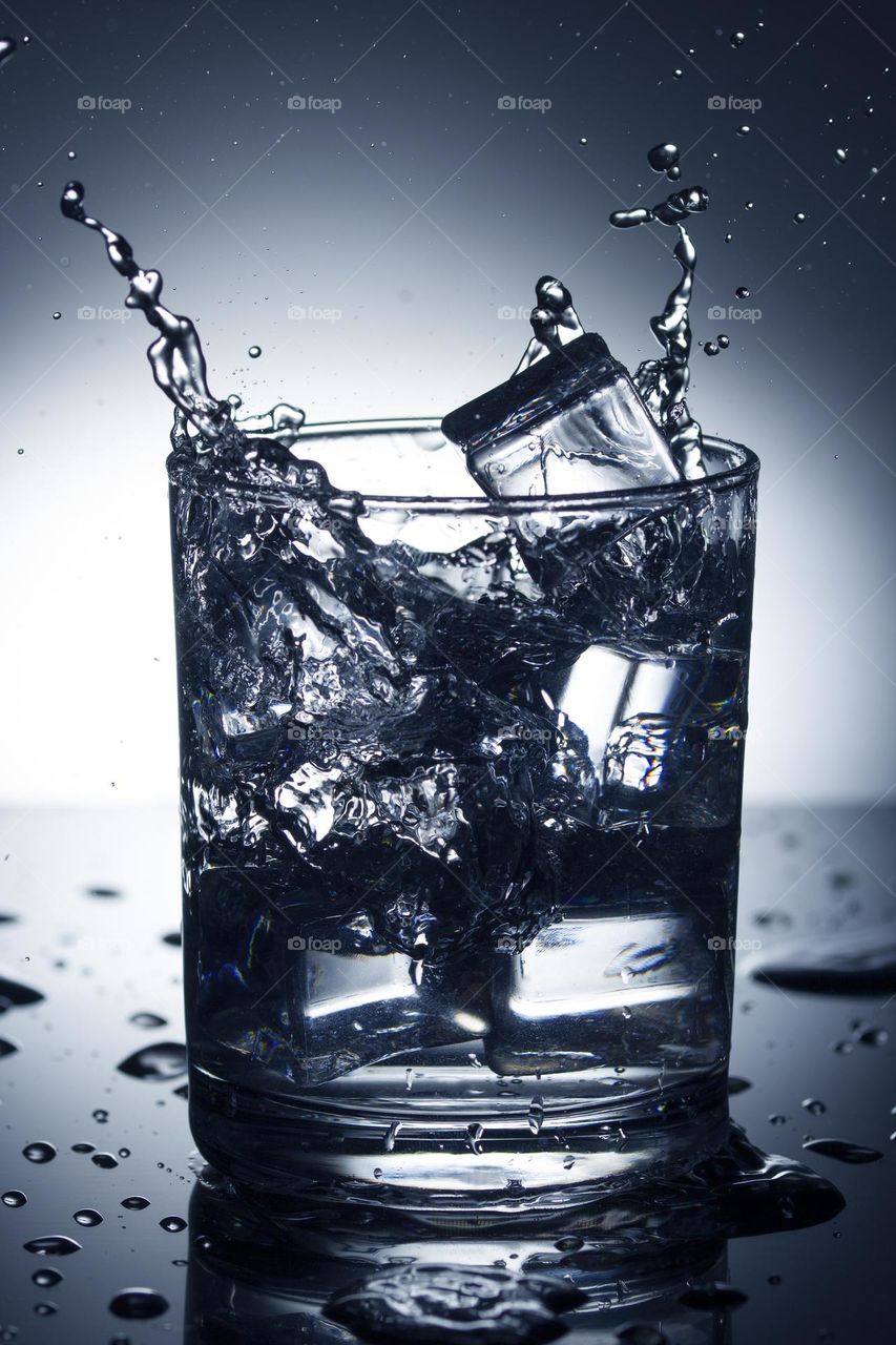 glass of water with splash from falling ice cube, black and white photo