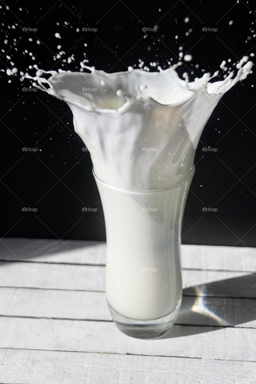 Milk splashing against black background