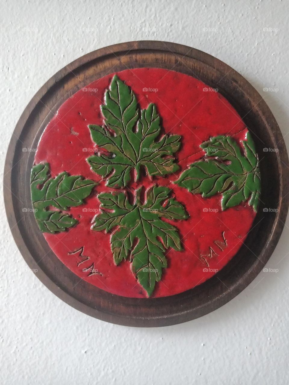 Ceramic art on a circle frame, painted leaves
