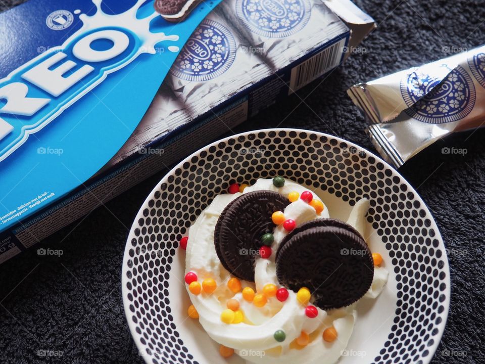 Oreo cookies with whipped cream and sprinkles.