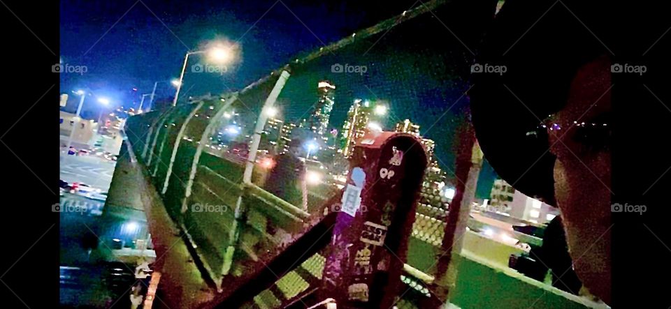 The pedestrian lane of the „Pulaski Bridge“ is along part of the way enclosed by a tall bent inward metal mesh fence so that people cannot accidentally fall in the water. 2023. Hypnotic Productions