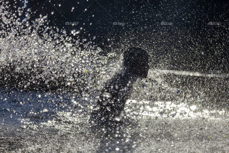 Silhouette of a boy in a fountain