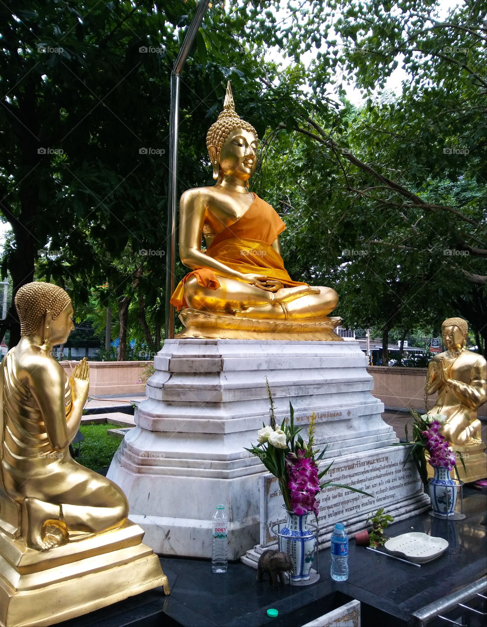 Golden buddha and disciples statue in the park.