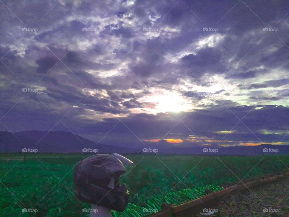 Helmet on the green grass under the clouds