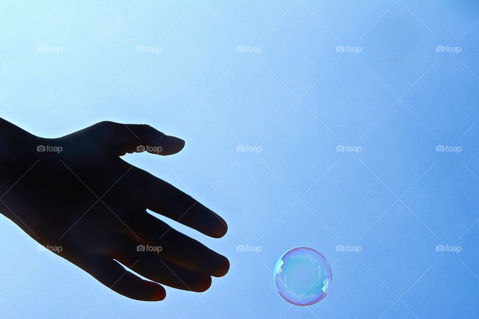 Hand Reaching for Bubble