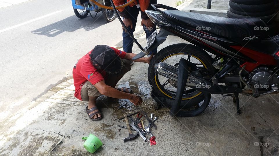 a mechanic who is repairing a motorbike