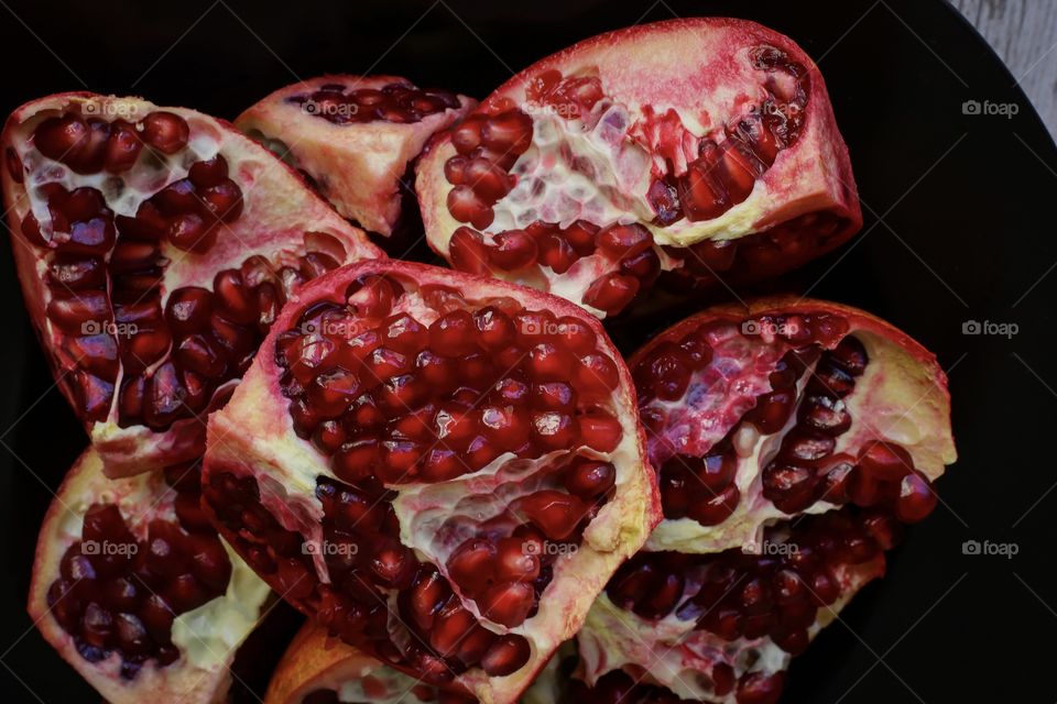 peeled pomegranate on a black plate