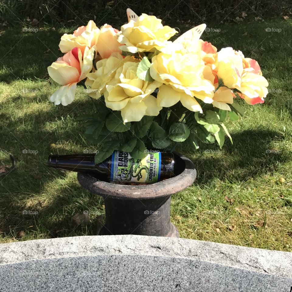An empty beer bottle littering a gravesite