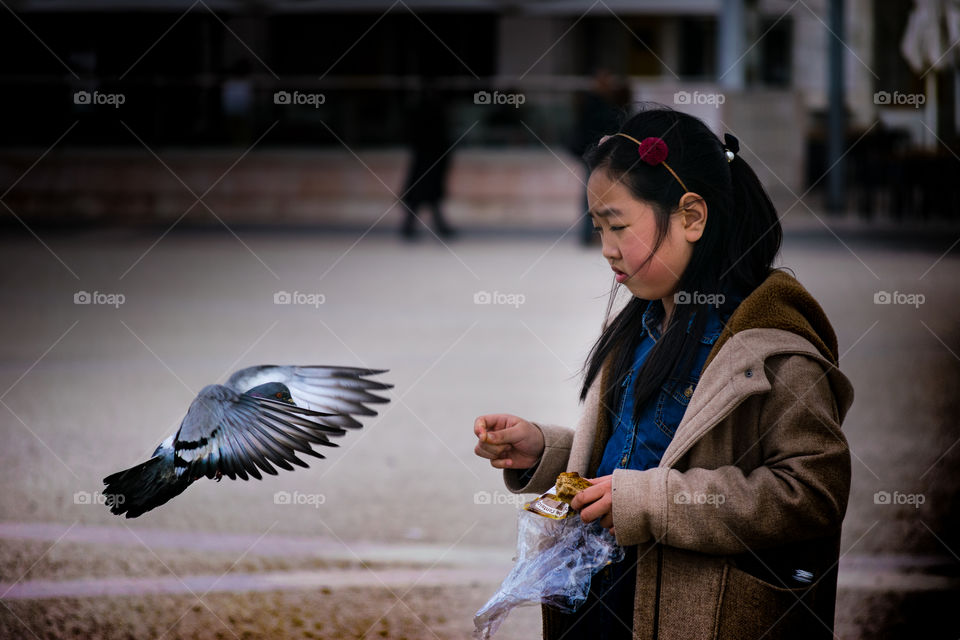 La niña y la Paloma. Aquí muestro el Justo instante en que esta niña da de comer a una paloma en la plaza del comercio de Lisboa.