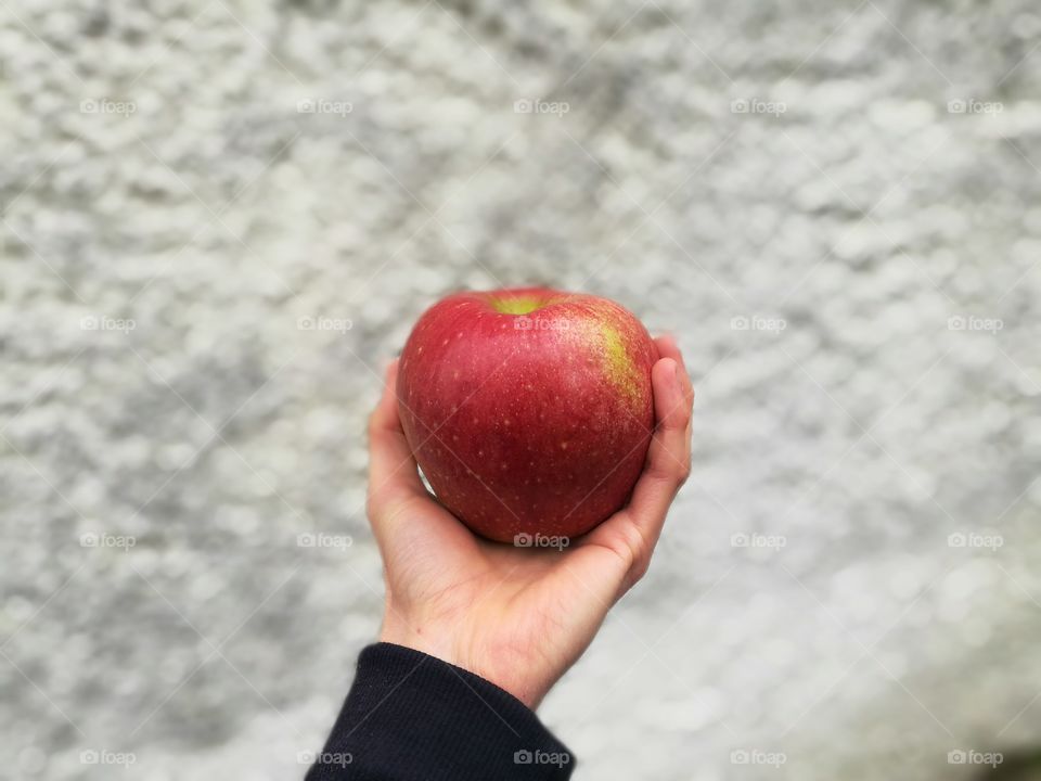 red apple on hand / background white wall