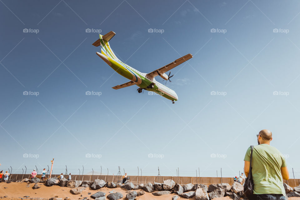 Low pass landing airplane over heads of people