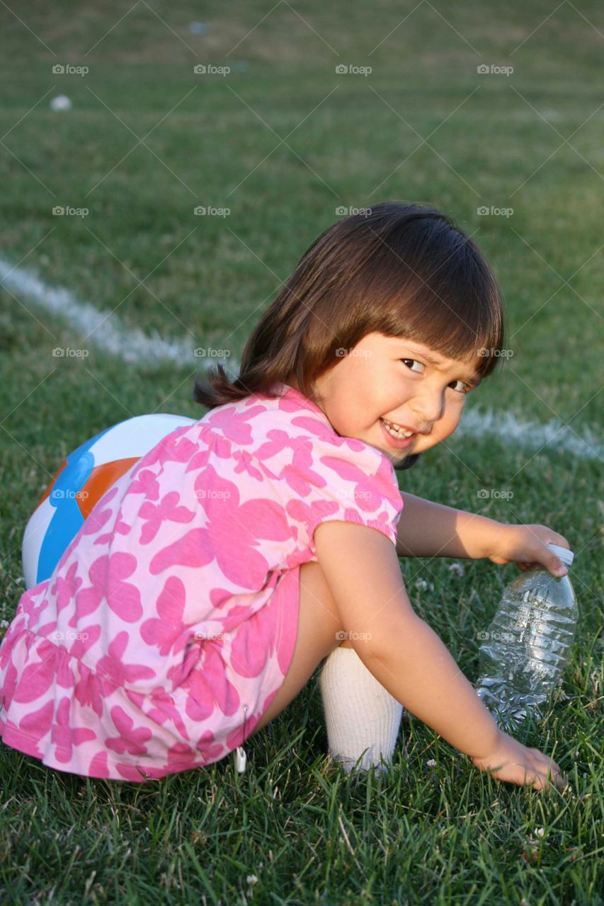 Asian girl playing on green grass