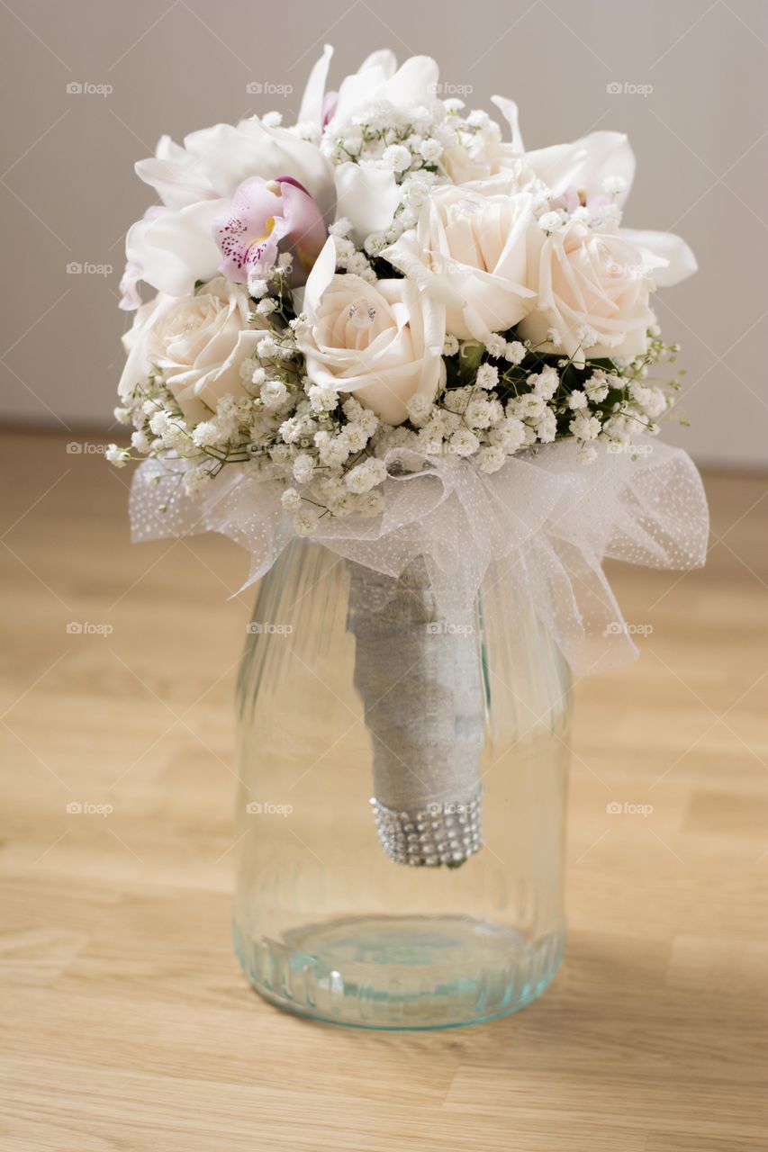 wedding bouquet in glass mug. wedding bouquet of white orchids and roses in big glass mug