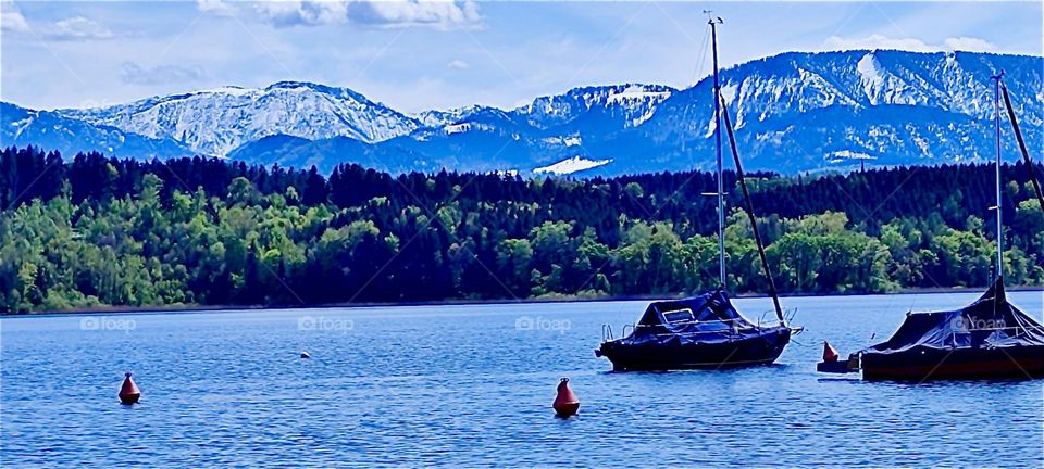 This is one of the lakes in the vicinity of „Bayerischzell“, a small township near the Alps in „Bavaria“, Germany. Glaciers with their iced over tops can be seen behind the forest covered hills. 2024. Hypnotic Productions
