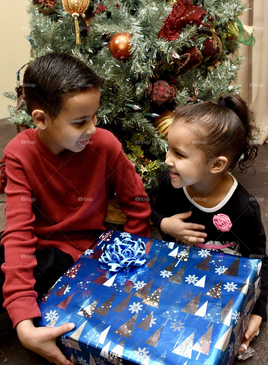Brother giving little sister a Christmas gift 