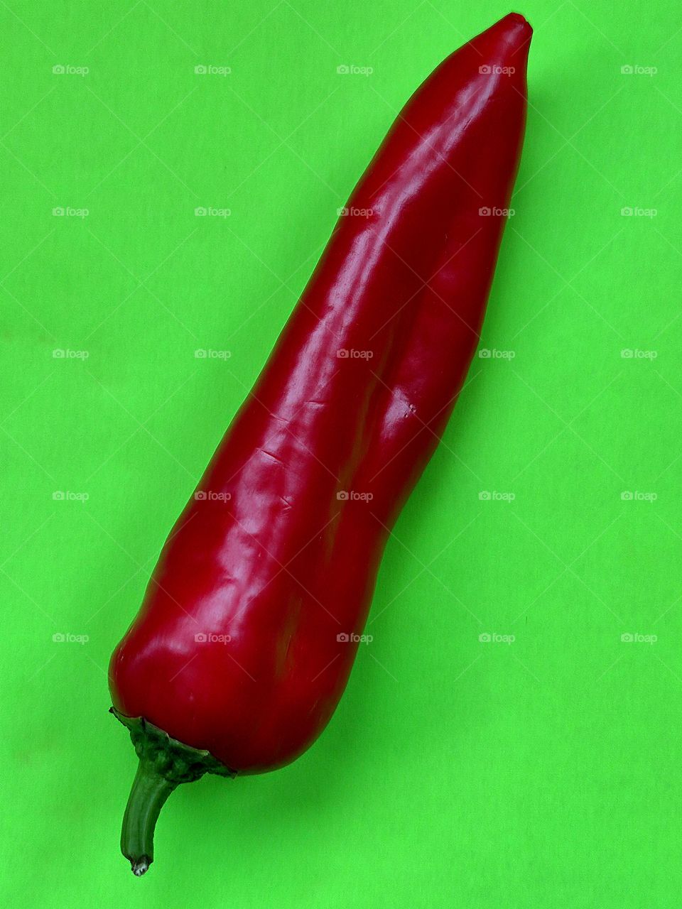 Red chili peppers on a light green background.  Color contrast