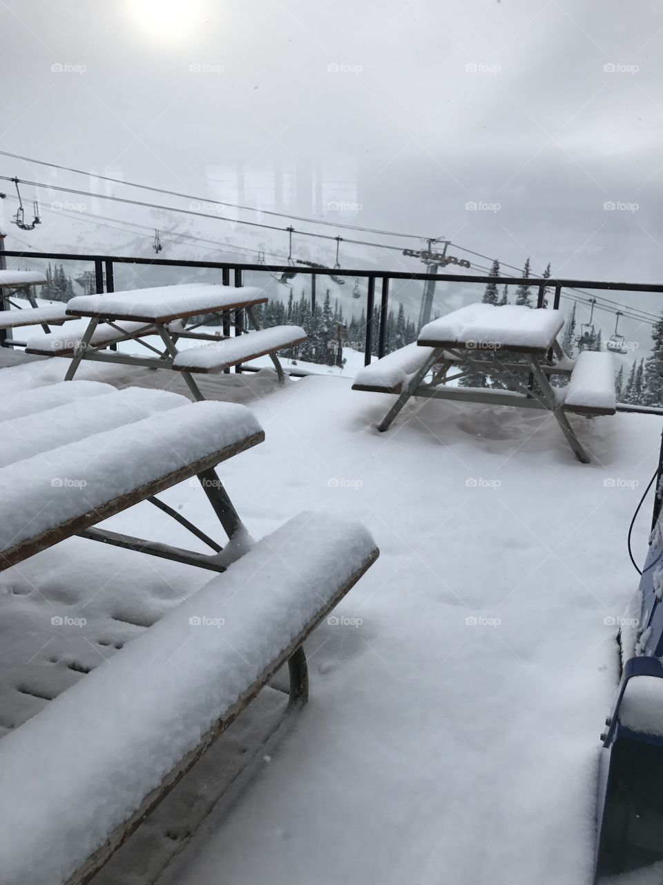 Snow scene on the mountain, snow covered table and chairs, top of whistler Canada 