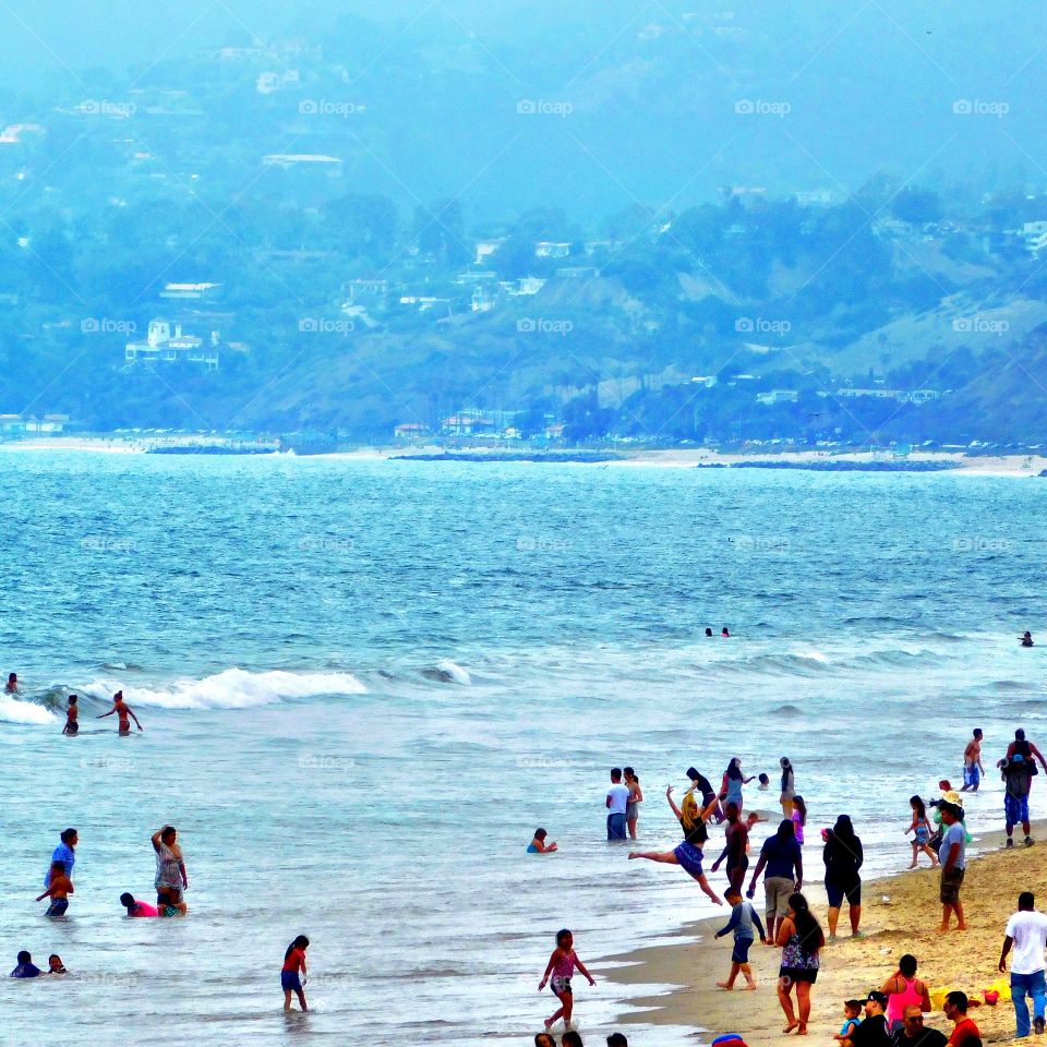 Tiny Dancer. Woman surprisingly caught jumping for joy in a candid shot on a hazy day at Santa Monica Beach, CA.
