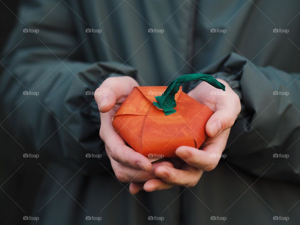 Unrecognisable woman holding in the hands handmade paper orange pumpkin 