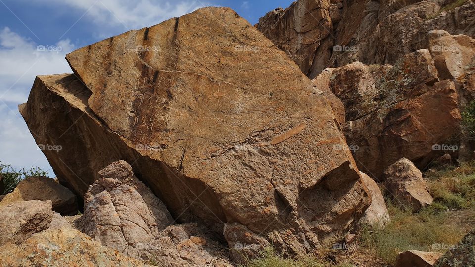 ancient writings and Buddah on the rock in Tamgaly tas