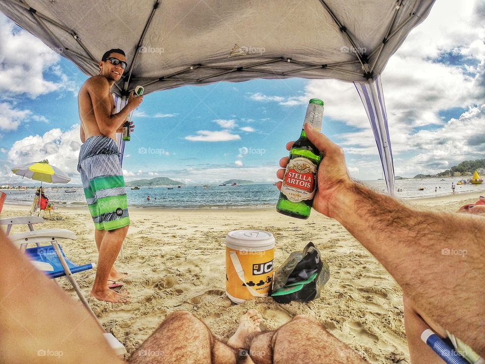 Shirtless man drinking on beach