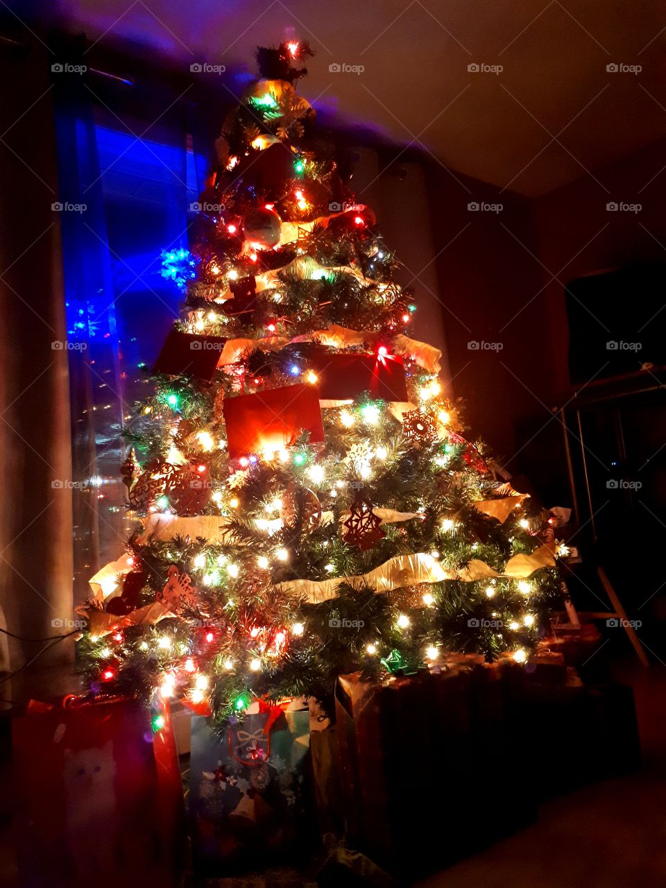 Christmas tree all decorated and lit up Christmas eve night