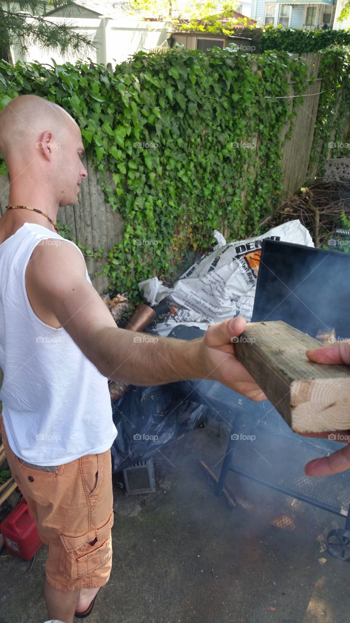 personal point of view, handing wood to a man for the barbeque
