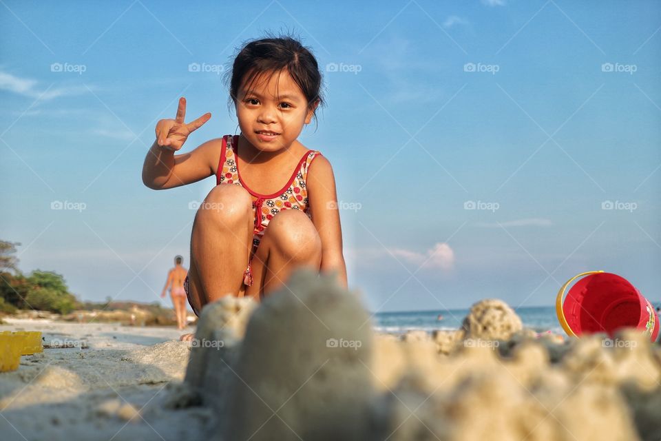 the girl playing the sand on the beach in the morning.