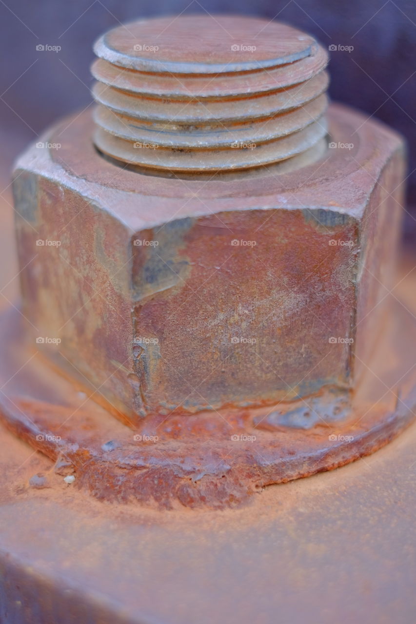 Big rusty metal nuts locked with rust and bolt