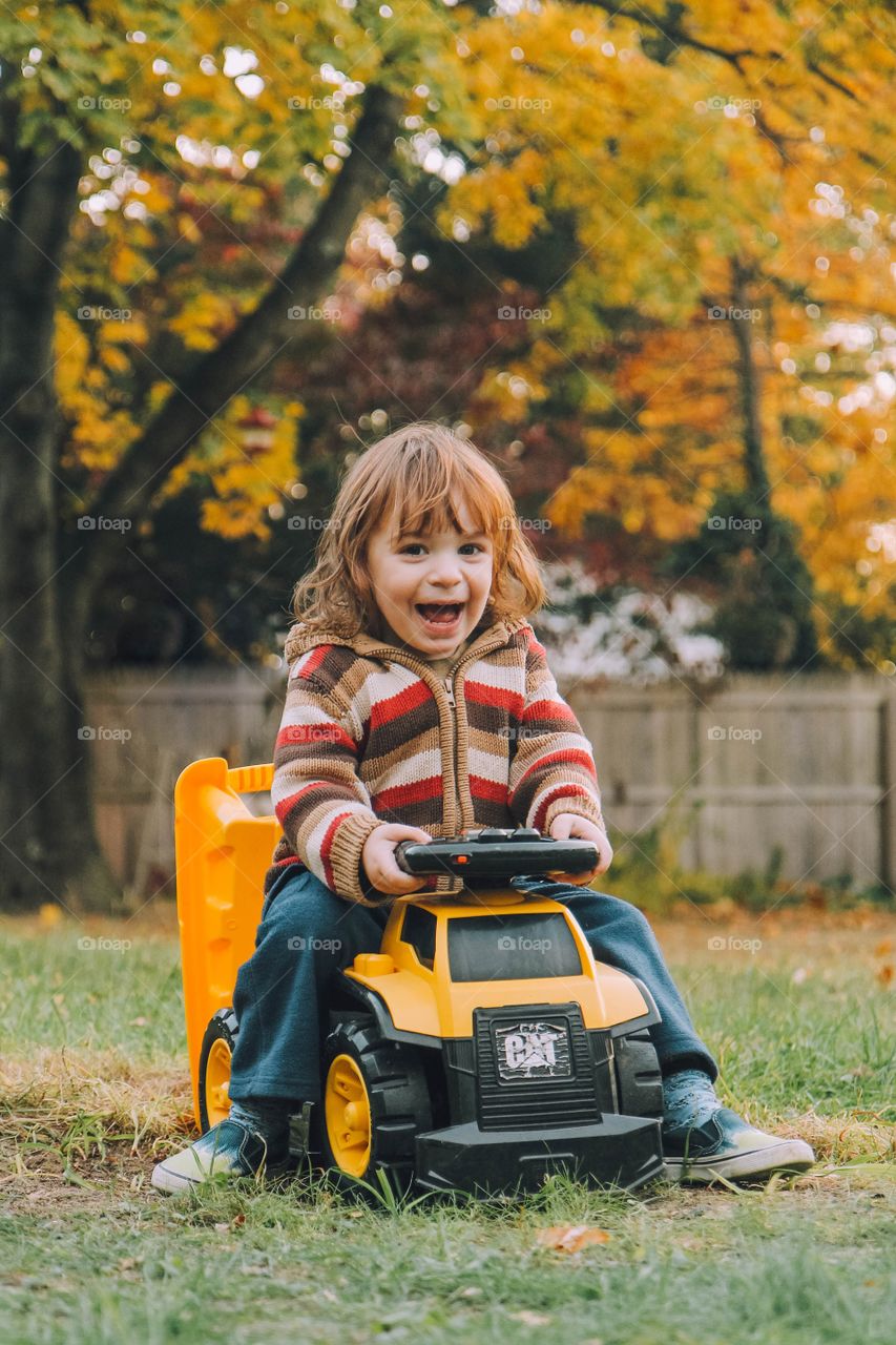 Little boy laughing sitting on a truck