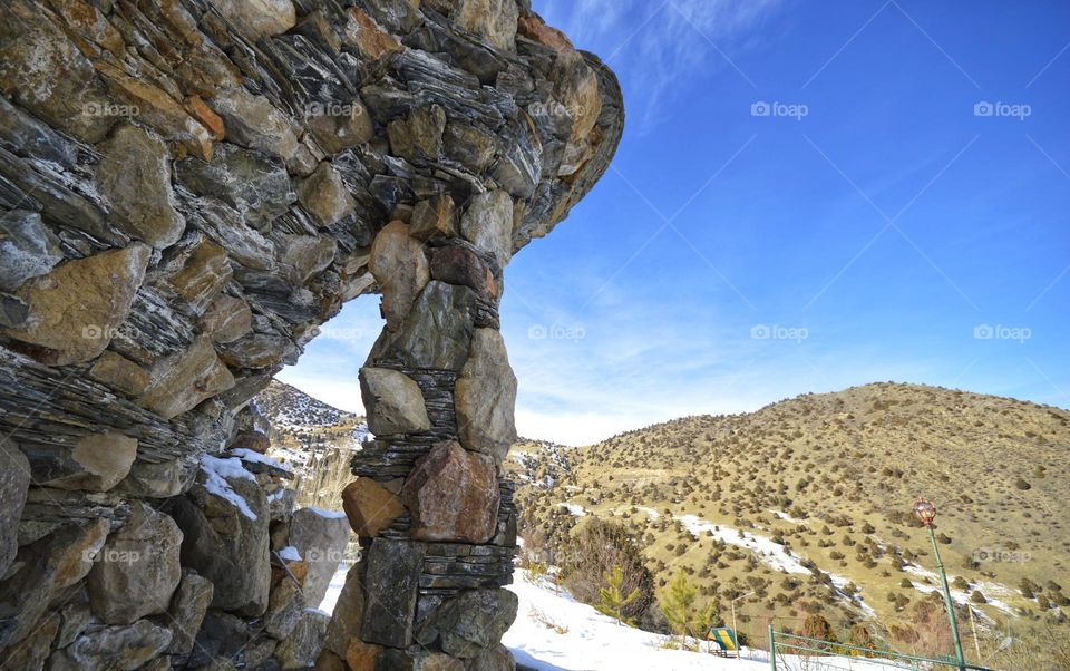 stone cliff propped up by stone columns. Pamir mountains point Asia.