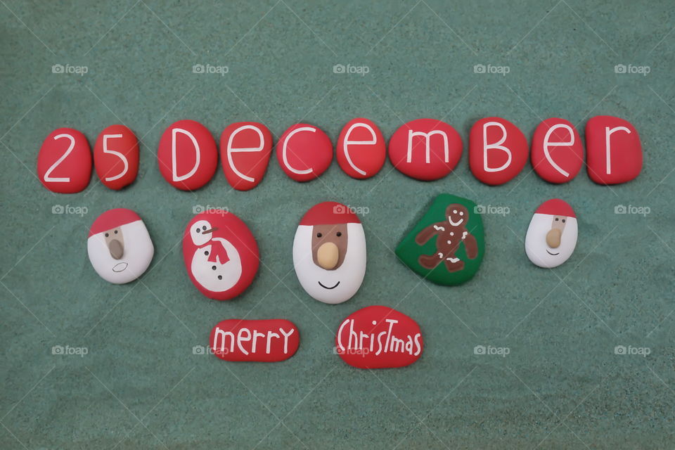 25 December, Merry Christmas background with carved and colored stones over green sand