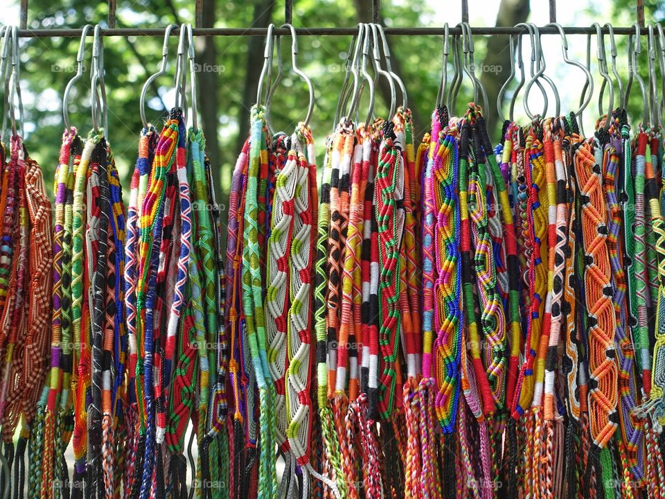 Colorful fabrics in various patterns hanging on hangers in a row outdoor
