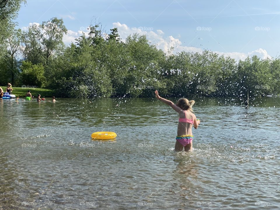 girl playing in the lake with water