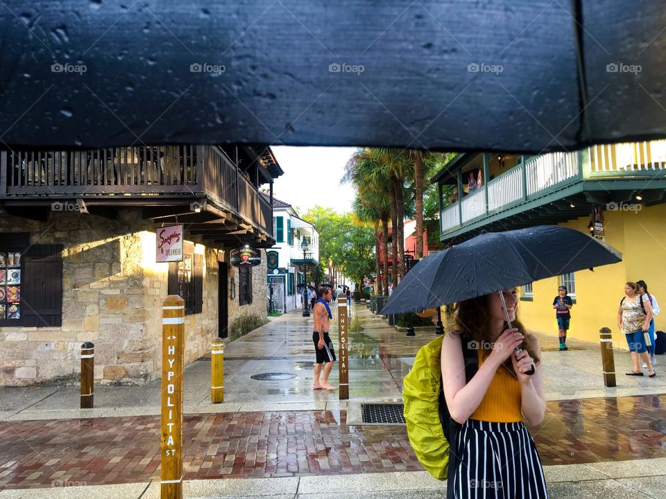 Girl under umbrella while walking in rain