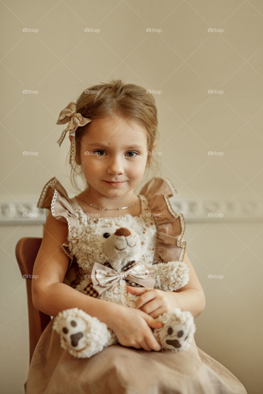 Vintage portrait of a beautiful little girl with teddy bear 