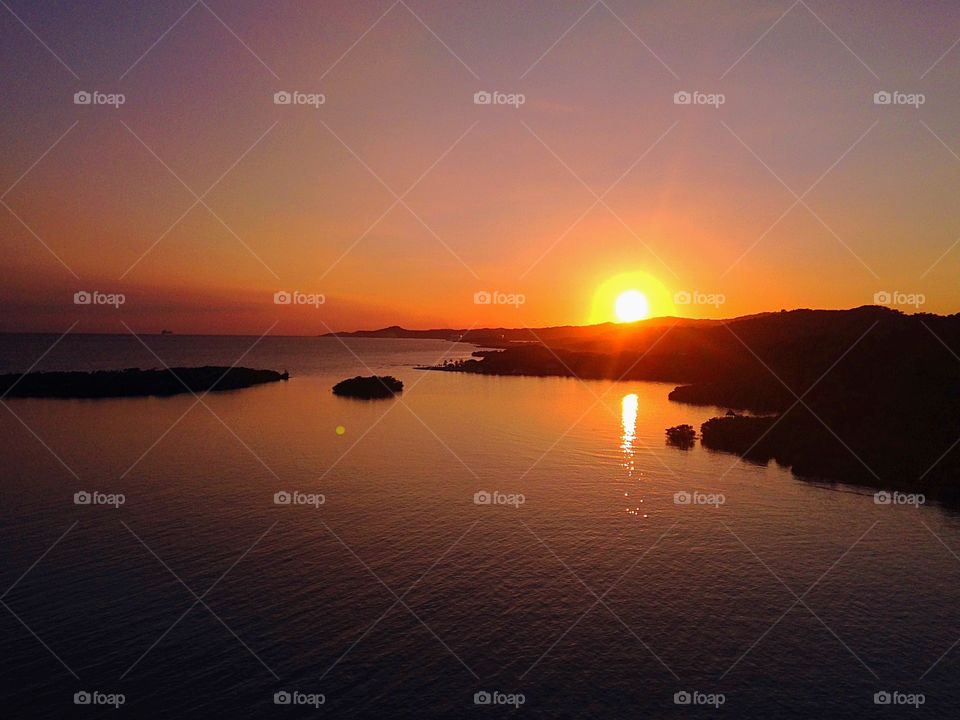 Sunset over silhouetted mountain at coastline