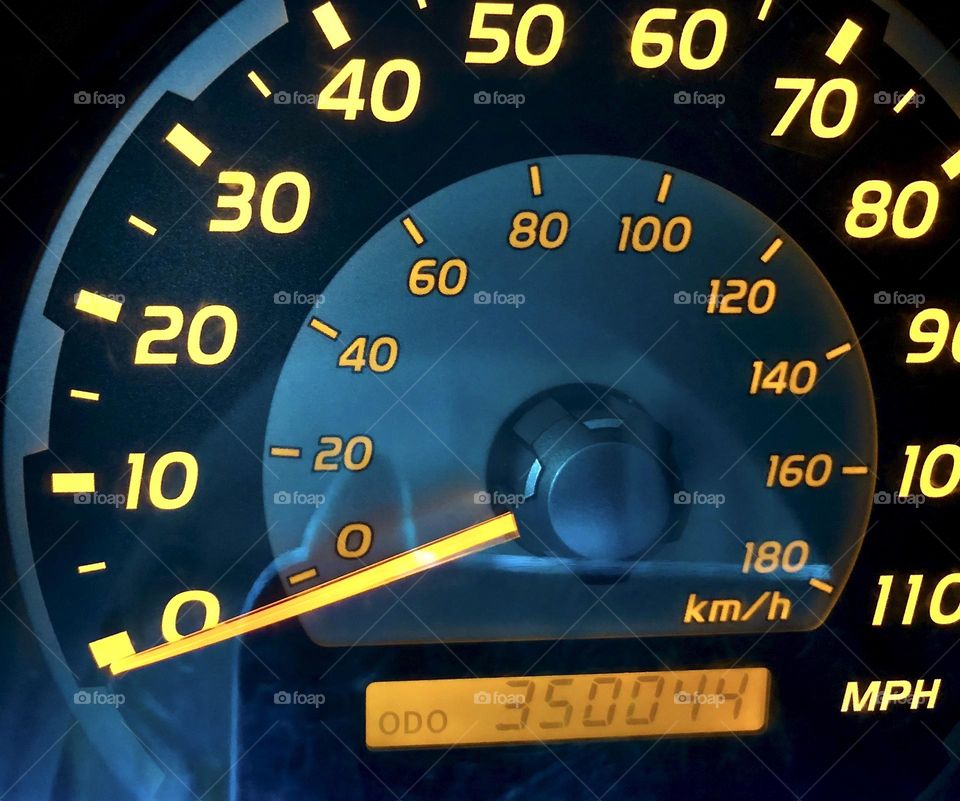 Racking up the mileage on road trips. Closeup of a car odometer with over 350K miles so far.